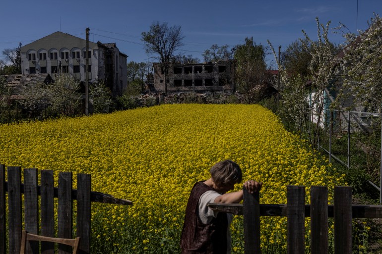 A woman takes a pause as she stands near a destroyed public building, as Russia's attack on Ukraine continues, in the town of Borodianka, Ukraine May 5, 2022. REUTERS/Carlos Barria