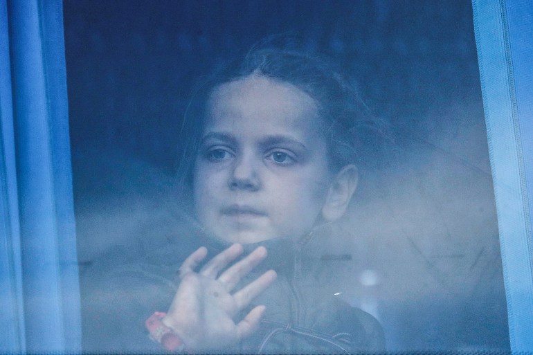 A girl looks through the bus window as civilians evacuated from Azovstal steel plant in Mariupol