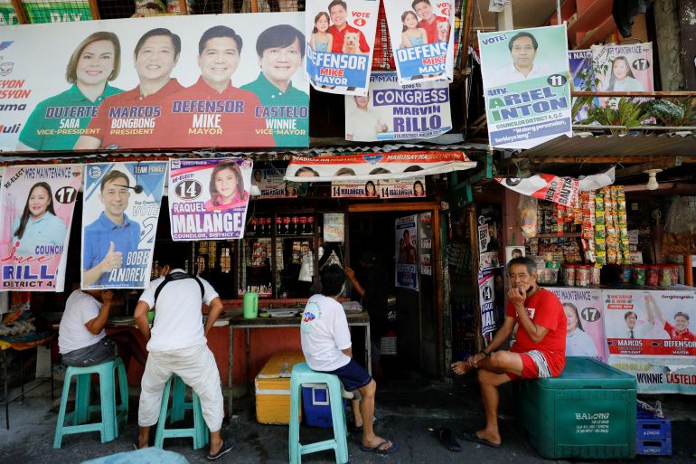 Residents sit at a stall with election campaign posters for the 2022 Philippine elections in Quezon City, Metro Manila, Philippines, May 7.