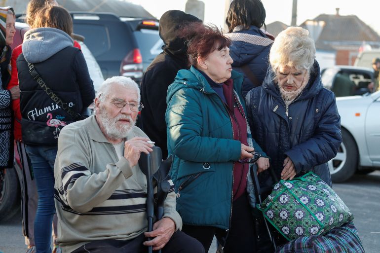 Civilians gather near buses carrying people, who were evacuated from Mariupol