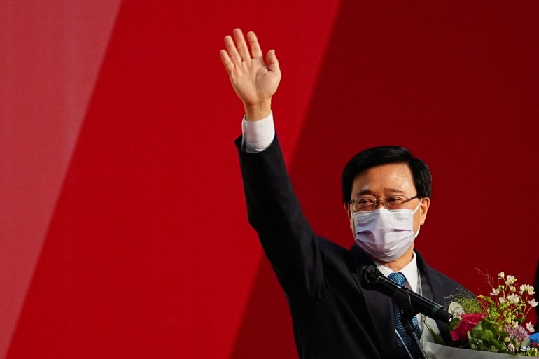 John Lee waves next to his wife Janet Lam Lai-sim after he was elected as Hong Kong's Chief Executive, in Hong Kong, China,