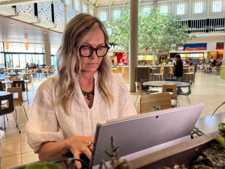 Christy Johnson travaille sur son ordinateur dans une aire de restauration d'un centre commercial après avoir expliqué à Reuters pourquoi elle est une électrice indépendante et comment elle prévoit de voter en novembre.