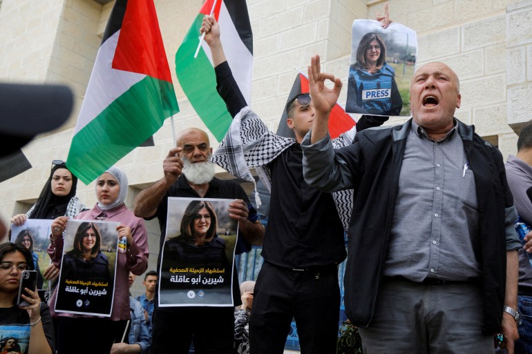 Palestinians hold pictures of Al Jazeera reporter Shireen Abu Akleh