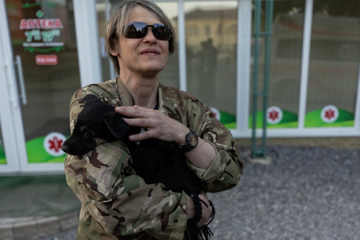 Elena Bulakhtina, a Russian-born Canadian from the Pirogov First Volunteer Mobile Hospital carries her dog Rica, who she rescued during a mission a few days prior, amid Russia's invasion in Ukraine, outside a hospital in Bakhmut