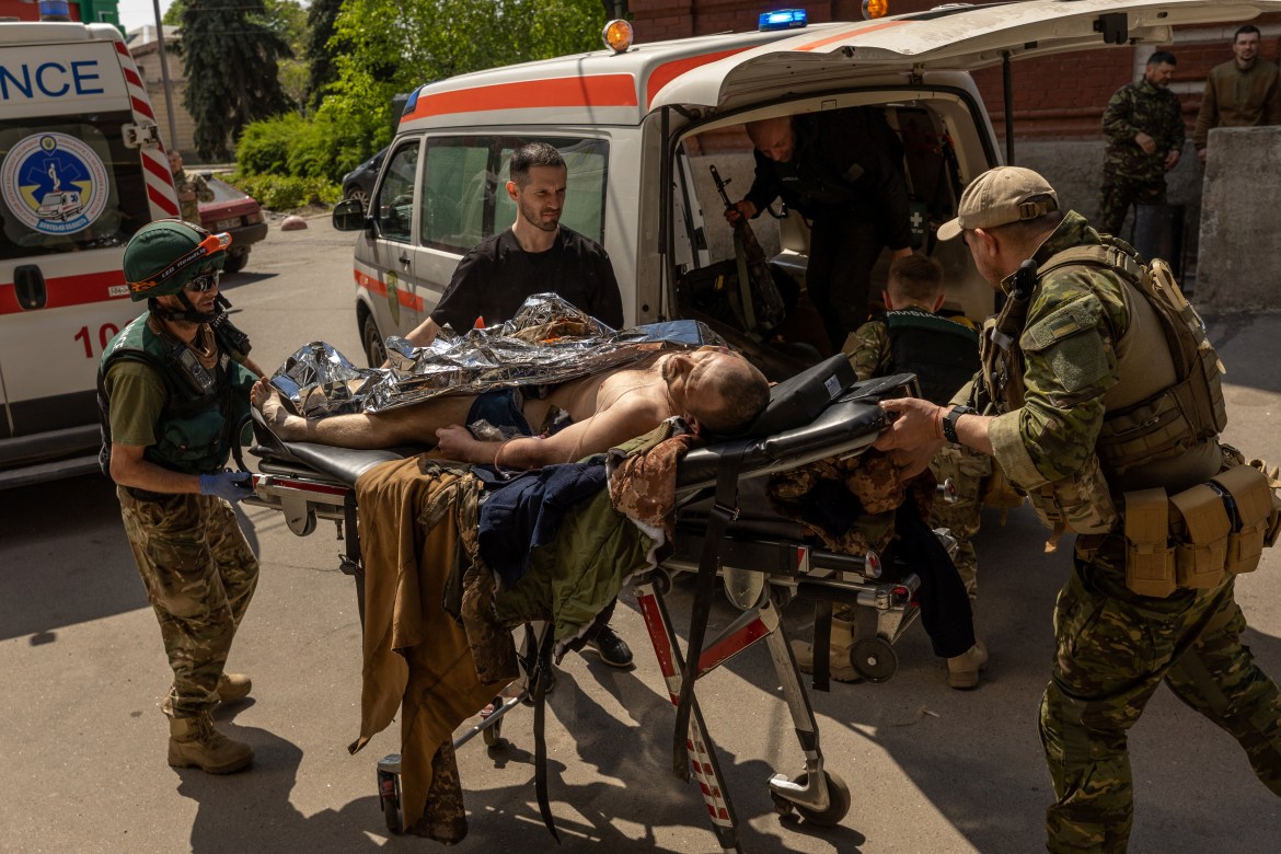 Paramedics from the Pirogov First Volunteer Mobile Hospital move an injured Ukrainian solider, who was evacuated from the front line in Popasna, from an ambulance
