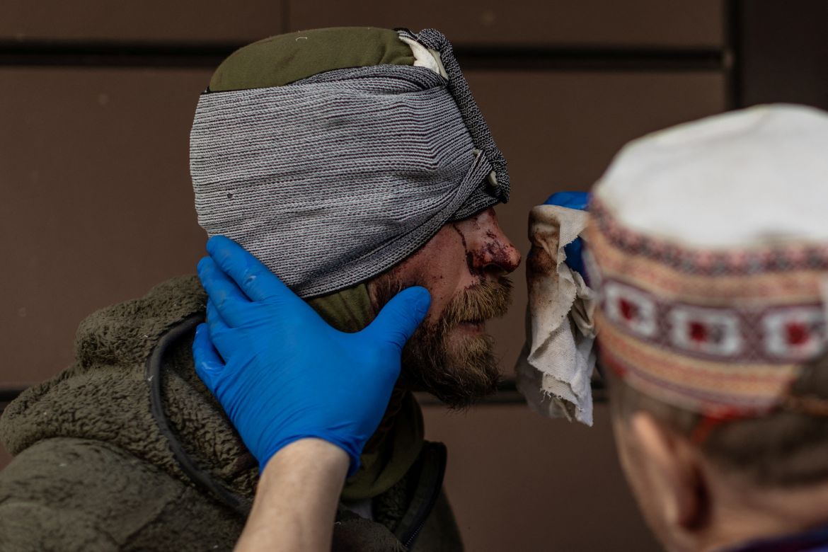 A nurse cleans blood from volunteer soldier Maksim, who was injured by shrapnel during combat in Popasna, amid Russia's invasion in Ukraine, outside the emergency room at a hospital in Bakhmut, Donetsk region