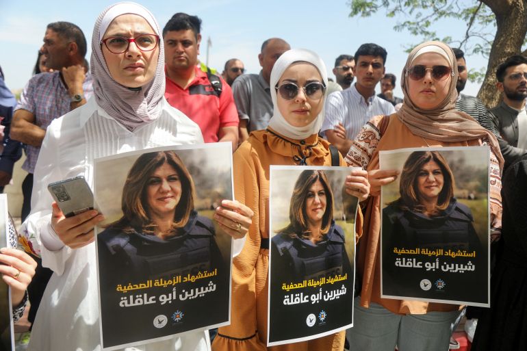 Palestinians hold pictures of Al Jazeera reporter Shireen Abu Akleh.