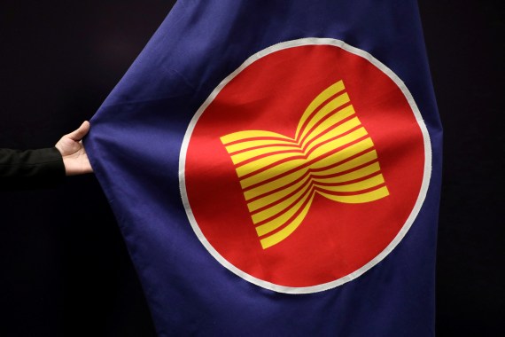 A close up of an ASEAN flag being adjusted by an official