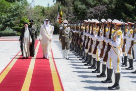 Iran's President Ebrahim Raisi walks with Qatari Emir Sheikh Tamim bin Hamad al-Thani