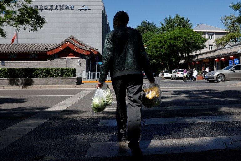 Man crosses street while carrying shopping bags