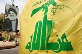 A Hezbollah flag and a poster depicting the group's leader Hassan Nasrallah
