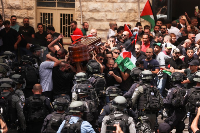 Family and friends carry the coffin of Al Jazeera reporter Shireen Abu Akleh, who was killed during an Israeli raid in Jenin in the occupied West Bank, as clashes erupted with Israeli security forces, during her funeral in Jerusalem, May 13, 2022. REUTERS/Ammar Awad