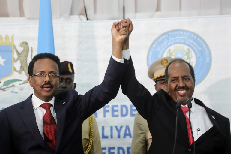 Somalia's newly elected president Hassan Sheikh Mohamud holds hands with incumbent president Mohamed Abdullahi Mohamed after winning the elections in Mogadishu,