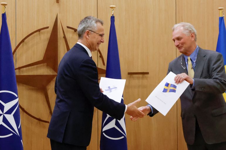 NATO Secretary-General Jens Stoltenberg and Sweden's Ambassador to NATO Axel Wernhoff shake hands during a ceremony to mark Sweden's and Finland's application for membership in Brussels, Belgium.