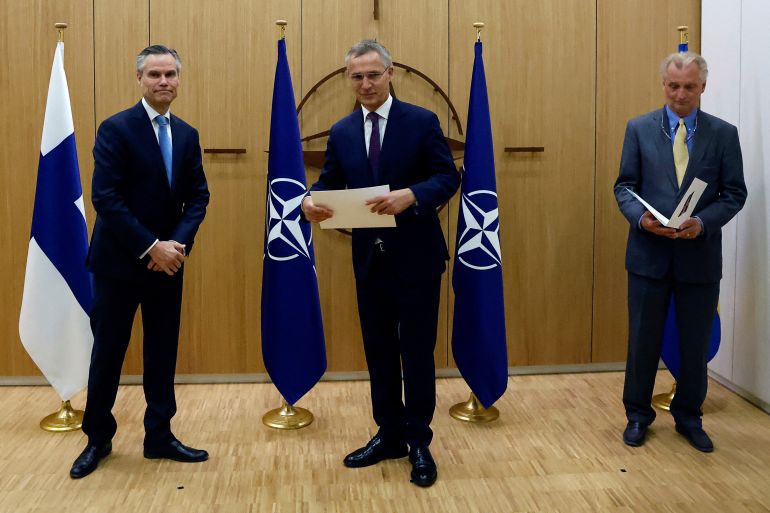 Finland's Ambassador to NATO Klaus Korhonen, NATO Secretary-General Jens Stoltenberg and Sweden's Ambassador to NATO Axel Wernhoff attend a ceremony to mark Sweden and Finland's application for membership in Brussels