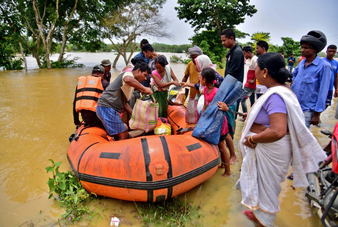 People disembark a boat after they were evacuated from a flooded village in Nagaon district, in the northeastern state of Assam