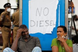 A couple waits in a queue to buy fuel at a station in Colombo [File: Adnan Abidi/Reuters]