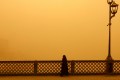 A woman walks on a bridge during a sandstorm in Baghdad, Iraq