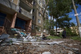 A local woman looks at an apartment building damaged by a Russian military strike, as Russia&#39;s attack on Ukraine continues, in the town of Vuhledar, in Donetsk region, Ukraine [Anna Kudriavtseva/Reuters]