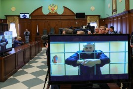 Navalny is seen on screens via a video link from the IK-2 corrective penal colony in Pokrov during a court hearing [Evgenia Novozhenina/Reuters]