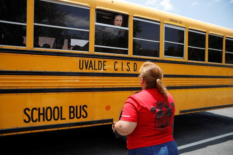 a school employee talks to someone in a school bus in Uvalde, Texas