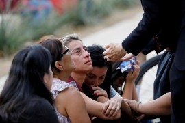 A woman reacts as Gustavo Garcia-Siller, archbishop of the Archdiocese of San Antonio, comforts people outside the SSGT Willie de Leon Civic Center [File: Reuters]