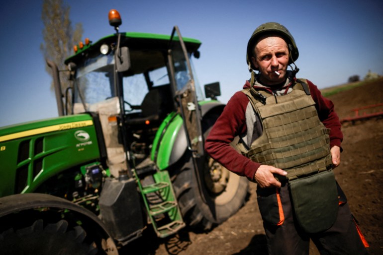 A Ukrainian farmer in a bulletproof vest and helmet while working in the fields in the Zaporozhye region, Ukraine, April 2022 [File photo: Ueslei Marcelino]