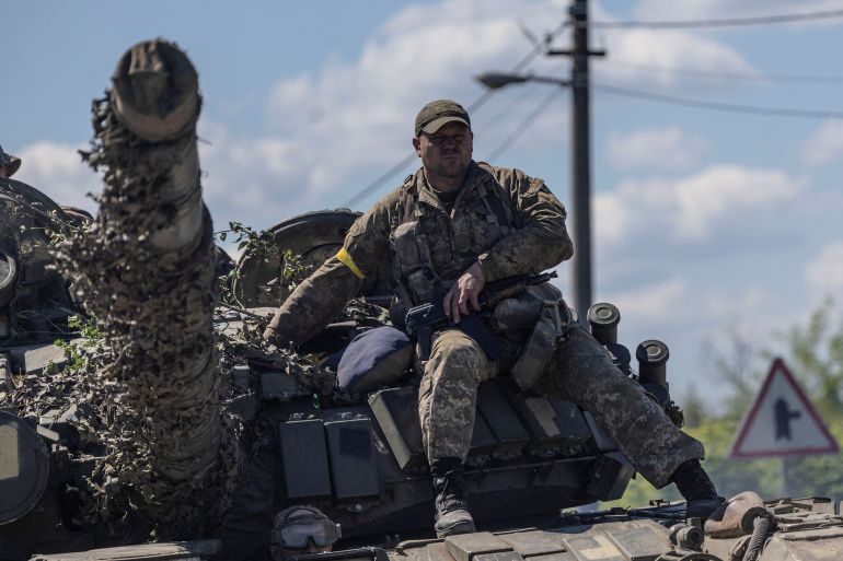 A Ukrainian fighter is seen sitting atop a tank in Donetsk, eastern Ukraine