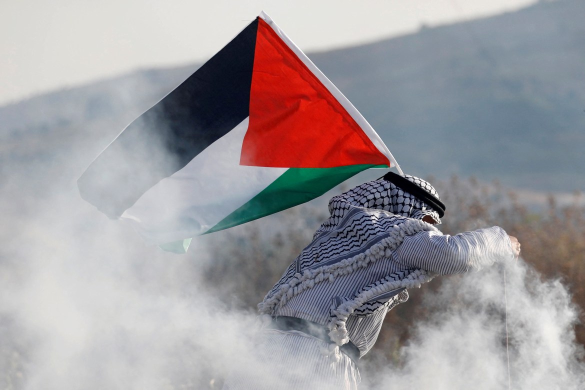 Palestinian holds a Palestinian flag during a protest in Nablus, occupied West Bank.