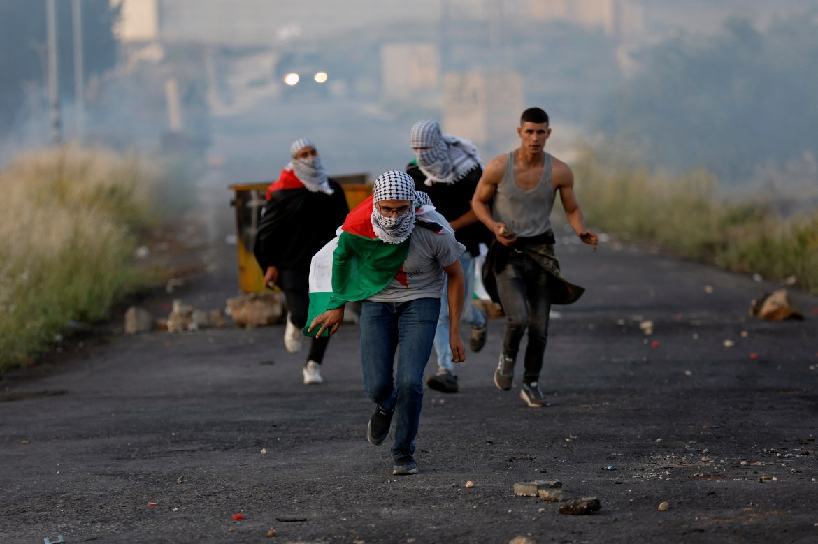 Palestinians run from Israeli forces in the Israeli-occupied West Bank .