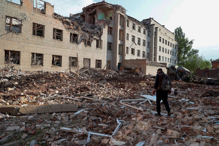 우크라이나 도네츠크 지역 바흐무트에서 한 주민이 러시아의 우크라이나 공격으로 파괴된 건물 옆을 걷고 있다.