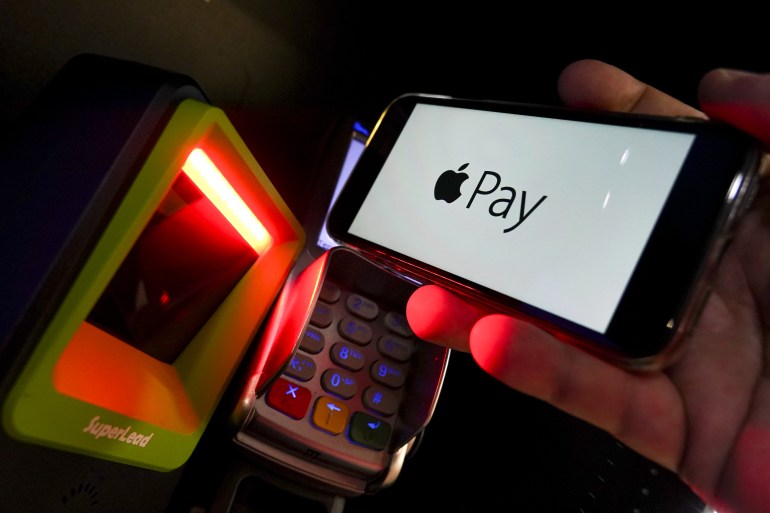 Apple Pay logo is displayed on a smartphone