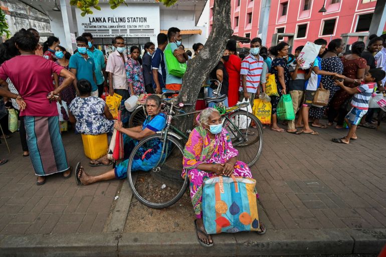 People queue up to buy kerosene for domestic use at a supply station in Colombo, Sri Lanka