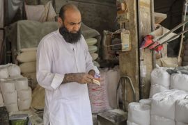A vendor at a wheat miller counts cash in Rawalpindi, Pakistan