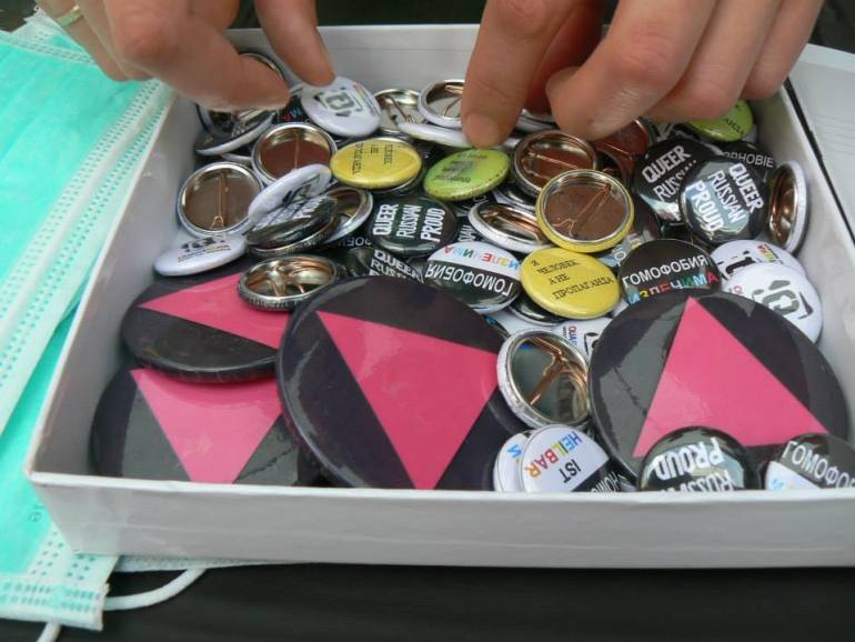 A photo of a box of buttons and badges.