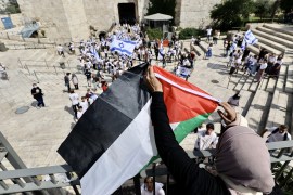 A Palestinian woman reacted to the march by unfurling the Palestinian flag.