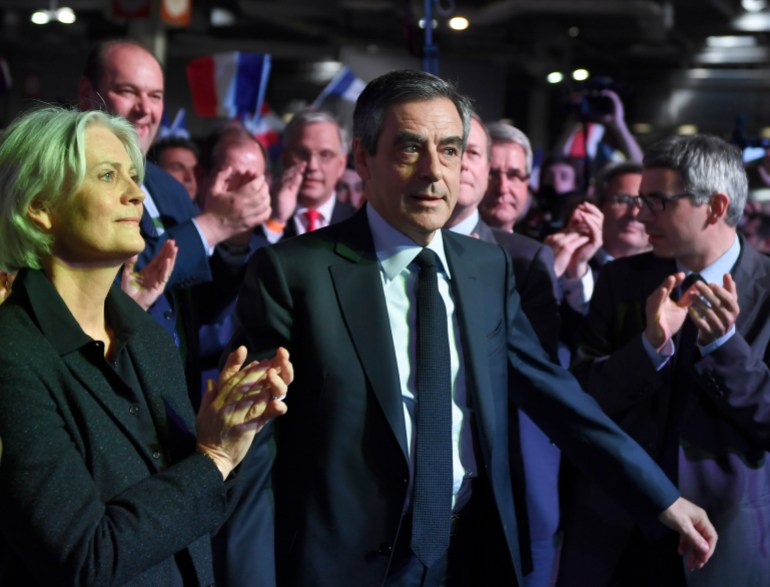 Conservative French presidential candidate Francois Fillon and his wife Penelope arrive for a campaign meeting in Paris