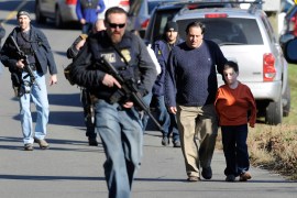 Parents leave a staging area after being reunited with their children following the massacre at the Sandy Hook Elementary School in Newtown, Connecticut in December of 2012 [File: Jessica Hill/The Associated Press]