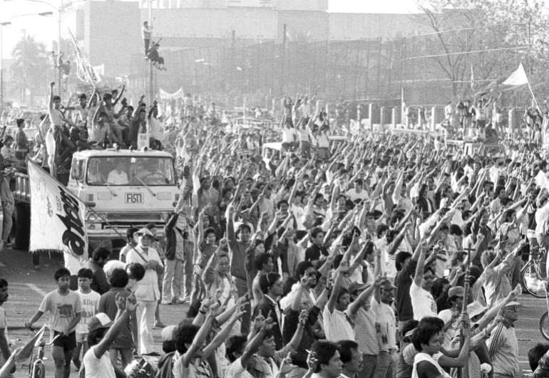 Filipinos cheer and raise their fists as they learn Ferdinand Marcos has fled the country in 1986