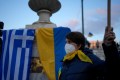 A woman is seen taking part in a rally against Russia's invasion of Ukraine, in Athens