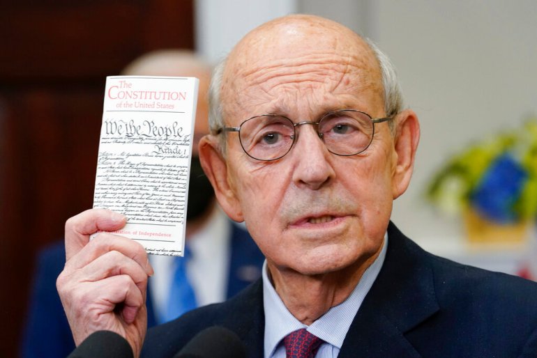 Supreme Court Associate Justice Stephen Breyer holds up a copy of the United States Constitution as he announces his retirement in the Roosevelt Room of the White House.