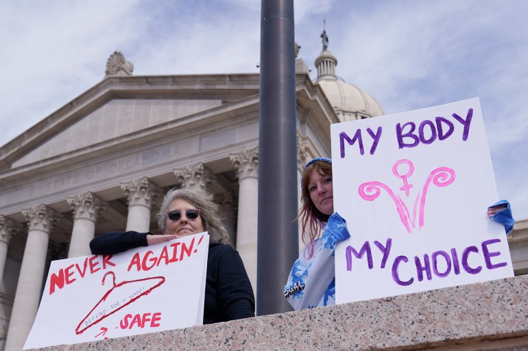 Women protesting in favour of abortion carry placards reading 'My body, my choice' and 'Never again' with a drawing of a coat hanger, which have often been used in backstreet abortions