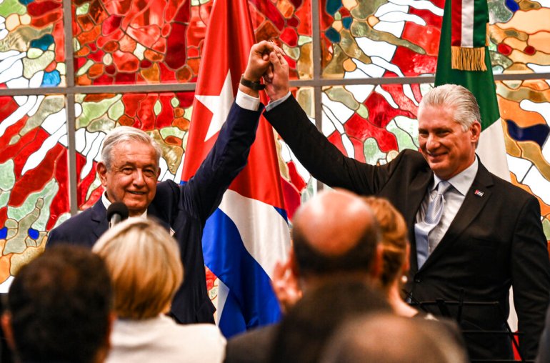 Cuban President Miguel Diaz Canel, right, and his Mexican counterpart Andres Manuel Lopez Obrador, left, raise their arms during a ceremony to award the Jose Marti order to President Lopez Obrador, at Revolution Palace in Havana, Cuba.