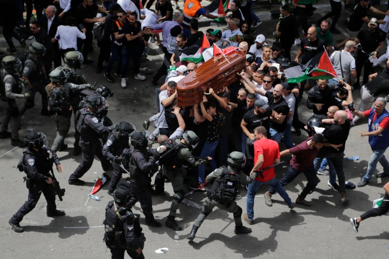 Israeli police confront with mourners as they carry the casket of slain Al Jazeera veteran journalist Shireen Abu