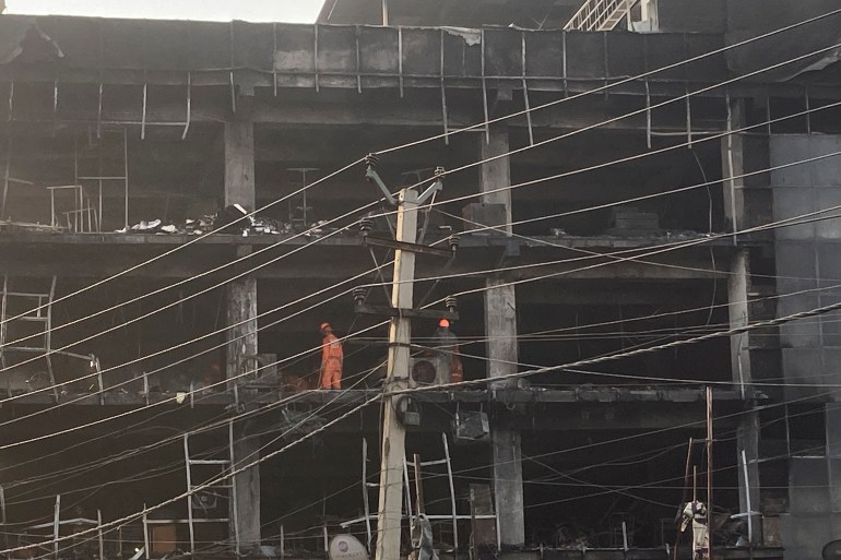 Rescuers work at the site of a fire in New Delhi, India, Saturday, May 14, 2022.