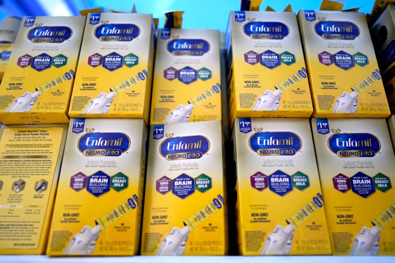 Infant formula is stacked on a table during a baby formula drive to help with the shortage May 14, 2022, in Houston. President Joe Biden has invoked the Defense Production Act to speed production of infant formula and has authorized flights to import supply from overseas