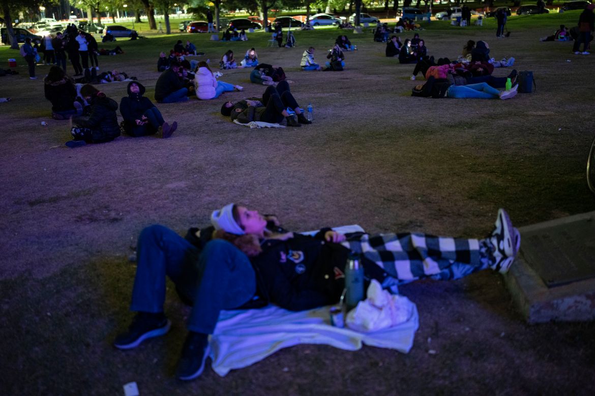 People gather around the planetarium to watch a lunar eclipse during the first blood moon of the year in Buenos Aires, Argentina