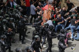 Israeli police confront mourners as they carry the casket of slain Al Jazeera veteran journalist Shireen Abu Akleh during her funeral in east Jerusalem