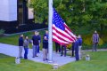 Employees of US embassy in Ukraine raise the US national flag at the US embassy, as Russia's attack on Ukraine continues, in Kyiv.