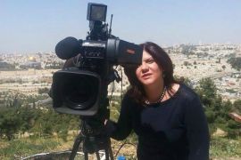 In this undated photo Shireen Abu Akleh stands behind a TV camera above the Old City of Jerusalem